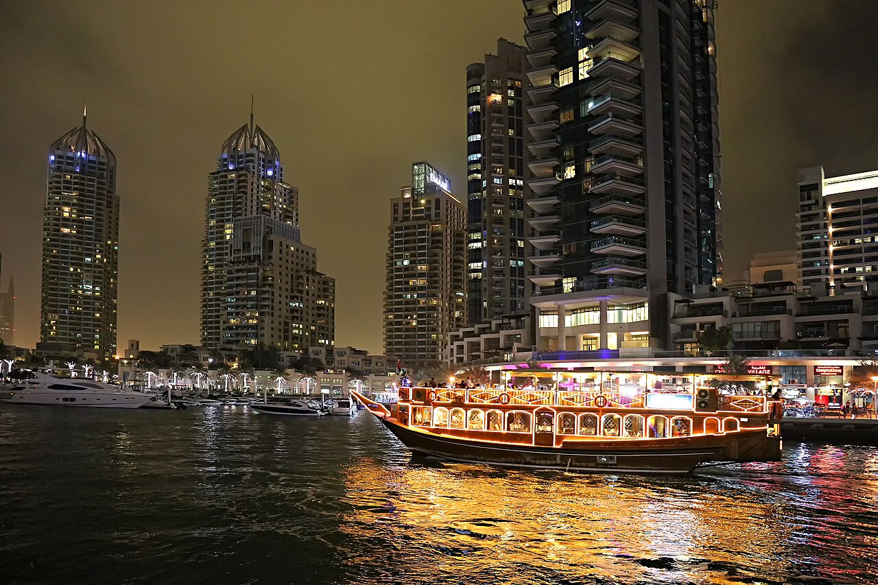 Luxury yacht cruising through Dubai Marina at night